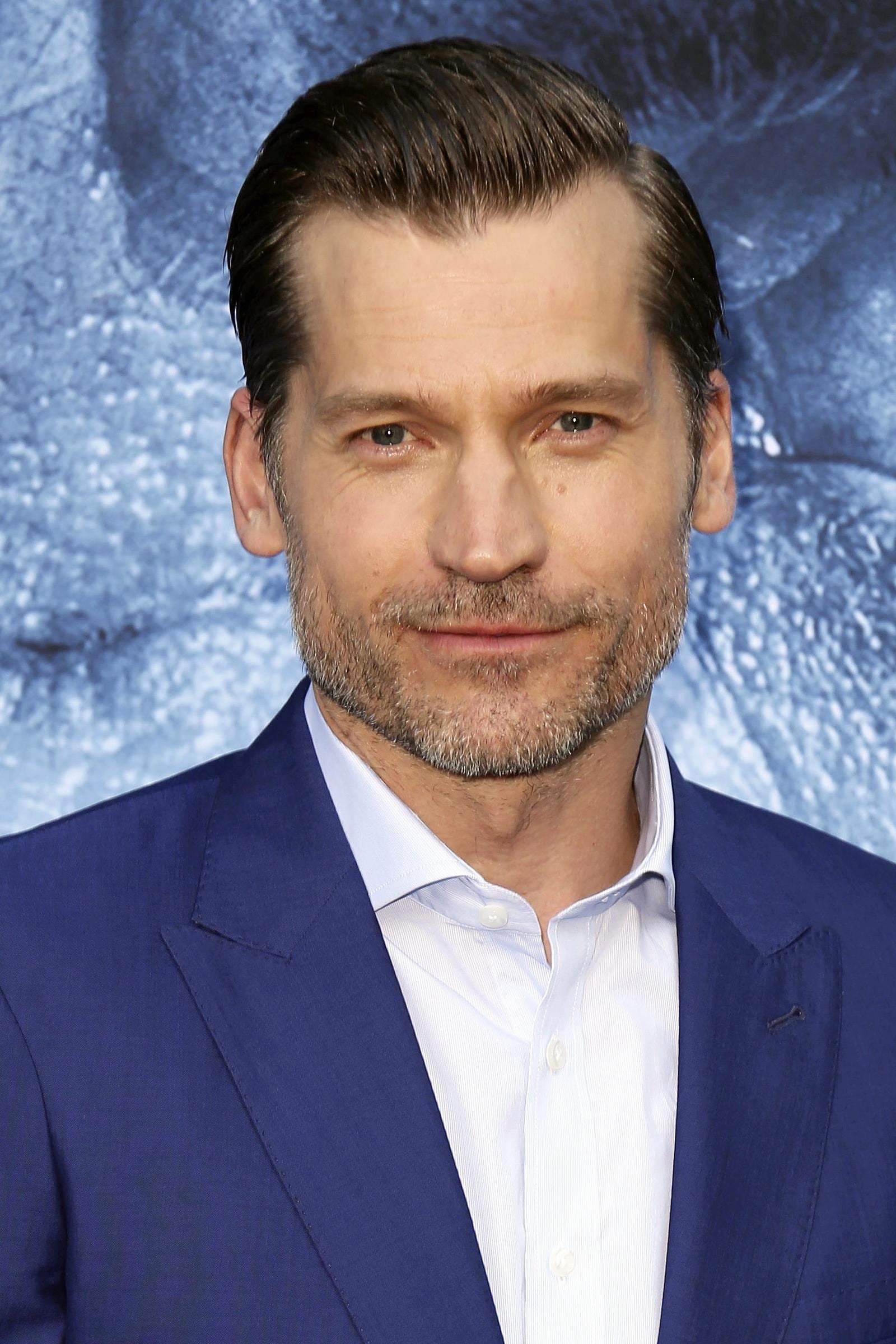 Nikolaj Coster-Waldau in a white shirt and a blue coat.